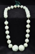 A Chinese carved jade bead necklace Approximately 50 cm long.