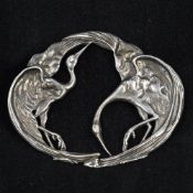 A late 19th/early 20th century silver buckle Formed as a pair of intertwined storks. 9.25 cm wide.
