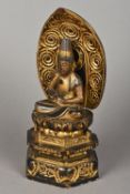 A lacquered carved wooden model of Buddha Modelled seated in the lotus position above a stepped