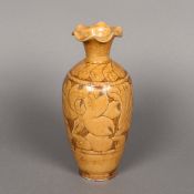 A Chinese porcelain vase With wavy rim above incised floral decoration, with allover ochre glaze.