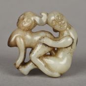 A Chinese mutton fat jade roundel Of pierced erotic form. 5 cm high.