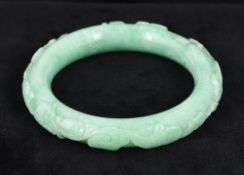 A Chinese carved jade bangle Carved to the exterior with a rodent amongst scrolling fauna.
