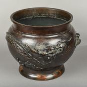 A late 19th/early 20th century Oriental patinated bronze jardiniere Decorated in the round with a