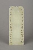 A Chinese carved celadon jade tablet Worked with precious objects within a pierced border.