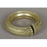 An African cast metal armlet Worked with gadrooned decoration. 14.5 cm diameter.