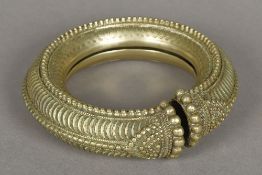 An African cast metal armlet Worked with gadrooned decoration. 14.5 cm diameter.
