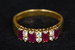 An 18 K gold diamond and ruby ring Set with four emerald cut rubies interspersed with three lots of