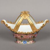 A Chinese porcelain basket Of navette form, the twin loop handle ribbon tied,