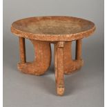 An African carved wooden tribal stool Of dished circular form with three pierced legs. 14.