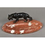 An Art Deco bronze mounted variegated marble desk stand The oval pen tray surmounted with the
