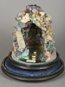 A specimen stone model grotto Of typical form, mounted on a mirrored plinth base,