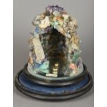 A specimen stone model grotto Of typical form, mounted on a mirrored plinth base,