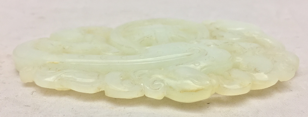 A Chinese carved celadon jade group Worked with stylised phoenixes flanking a spoked wheel. 8. - Image 4 of 4