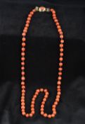 A single strand coral bead necklace Each bead interspersed with links,