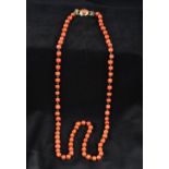 A single strand coral bead necklace Each bead interspersed with links,