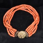 A five strand coral bead necklace Set with an ornate gold clasp. Approximately 36 cm long.