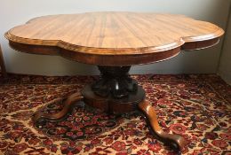 A Victorian rosewood loo table The hinged shaped top above the carved bulbous column,