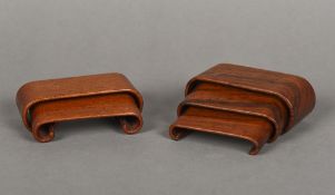 Five Chinese carved hardwood stands Each with scroll ends. The largest 10 cm wide.