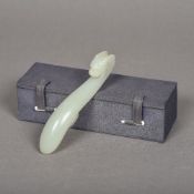 A Chinese carved celadon jade belt hook Of typical form, with dragon mask terminal, in fitted box.