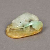 A Chinese carved green and russet jade group Worked as a toad on a lily pad. 5 cm long.