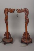 A pair of early 20th century Chinese carved hardwood table lamps Each formed as a dragon,