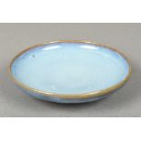 A Chinese Jun-ware porcelain dish With allover mottled blue glaze, standing on a shallow foot.