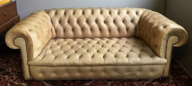 A vintage leather covered buttoned Chesterfield settee Of typical scrolling form,