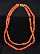 A two strand coral bead necklace Set with a plain gold clasp. Approximately 48 cm long.