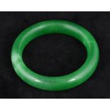 A Chinese apple green jade bangle Of plain form. 8 cm diameter.
