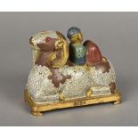 A Chinese cloisonne group Worked as a figure reclining on a recumbent ram,