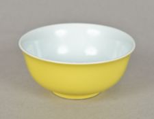 A Chinese porcelain bowl The exterior decorated with a plain yellow ground,