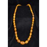 An amber bead necklace The oval beads o