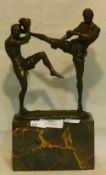 A bronze figural group of kickboxers