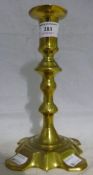 A late 18th century English petal based brass candlestick