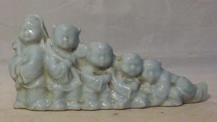 A porcelain brush rest in the form of five boys