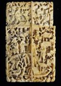 A 19th century Chinese Canton ivory card case deeply carved with figures in a landscape