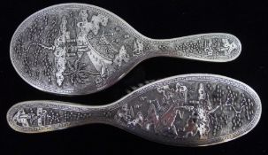 A late 19th century Chinese silver hand mirror intricately worked with a figure on a bridge in a