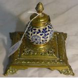 A Victorian brass mounted pottery inkwell The spherical body worked with floral strapwork.