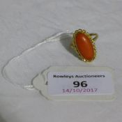 An unmarked coral set ring