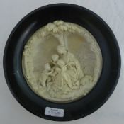 A 19th century ceramic roundel worked with Mary and the infant Jesus with a young John the Baptist