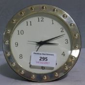 A silver round front clock