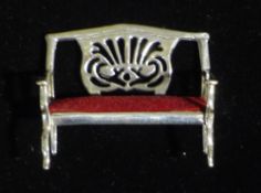 A miniature silver sofa