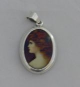 A silver miniature pendant depicting a girl