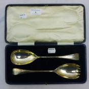 A pair of cased silver salad servers