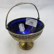 A silver sugar basket with a blue glass liner