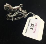 A miniature silver rocking horse