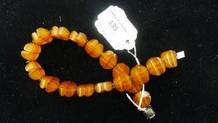 An amber necklace carved in segment form and interspersed with silver beads