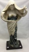 An Art Nouveau style figurine of a young lady with breasts exposed