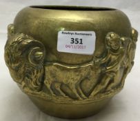 A 19th century brass vase decorated in relief with putto and a ram's mask