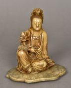 A Chinese carved Shoushon stone figure of Guanyin Modelled seated holding a lotus flower.